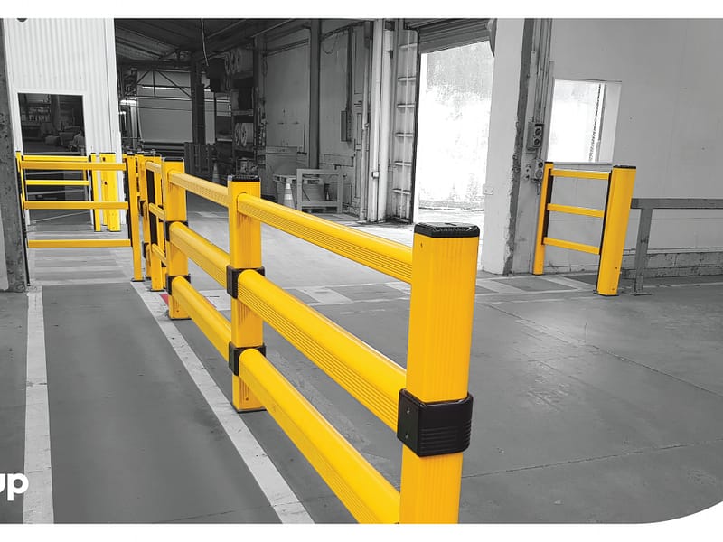 Yellow polymer safety barriers and pedestrian gates in a warehouse.